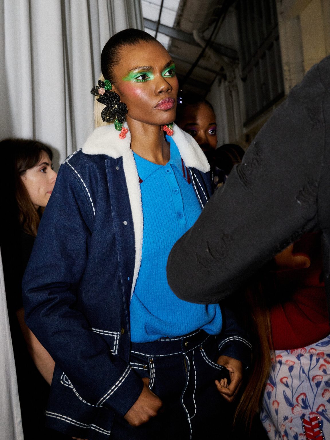 Model wearing the blue merino wool sweater under a denim jacket.
