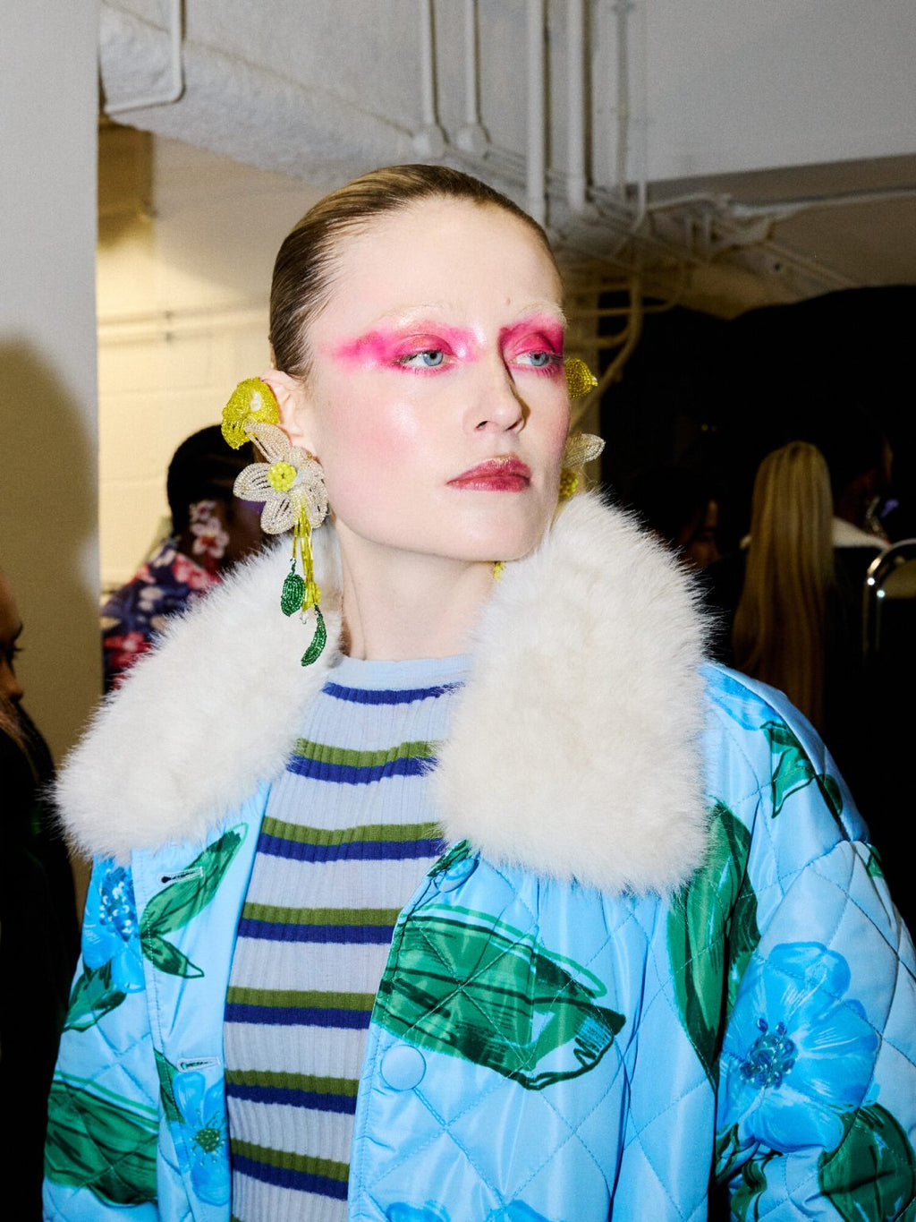 Modell med lys blå quiltet jakke med blomsterprint og hvit faux fur-krage.